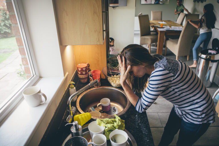 stressed mom at messy kitchen sink