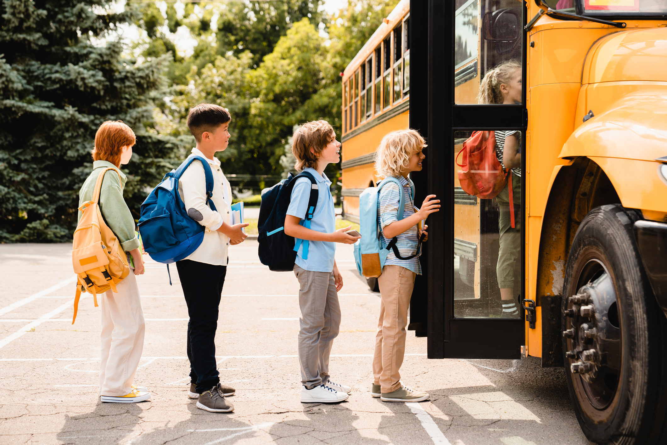 school children students standing in line waiting for boarding school bus before starting new educational semester year after summer holidays - At Home With Mackenzie Kids waiting in line to board the school bus
